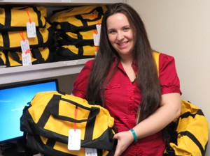 Kristina Spencer with duffels she has filled for acutely abused children discharged to foster homes.