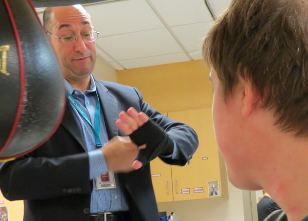 Dr. Astion shows Isaac how to wrap his hands for protection.